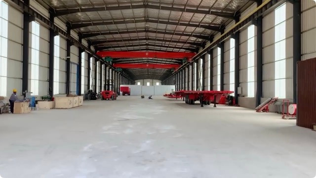 厂房内可见红色挂车底盘及起重设备。